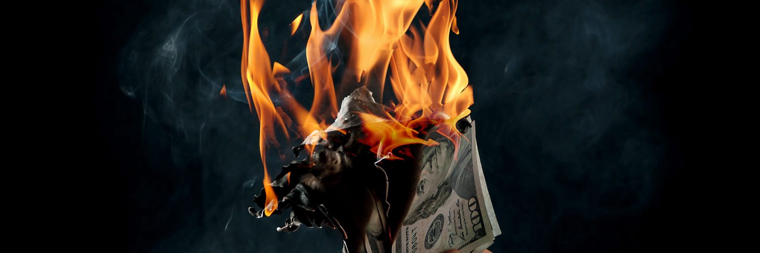 Man holding burning money