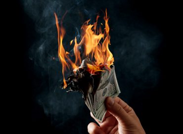 Man holding burning money